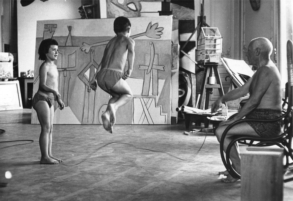 David Douglas Duncan. Palomba, Claude, y Pablo Picasso saltando a la comba delante de “Bañistas en La Garoupe”, Villa La Californie, 1957. ©SUCESIÓN PABLO PICASSO, V EGAP, MADRID, 2023 ©DAVID DOUGLAS DUNCAN