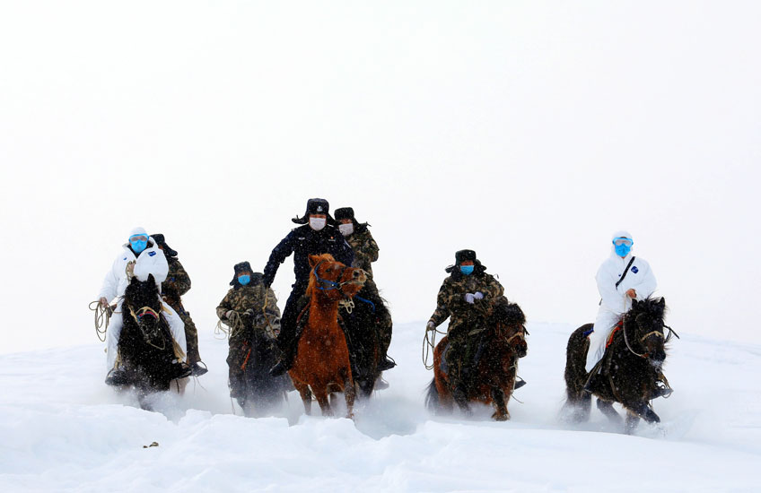 Las autoridades chinas viajan por la nieve para inspeccionar una zona fronteriza en las montañas y para proporcionar información sobre el COVID-19 a los residentes de una zona remota de Altai, en la provincia de Xinjiang, China. Se trata de unas imágenes de propaganda del gobierno chino dirigidas al extranjero. 19 de febrero de 2020. Agencia EFE