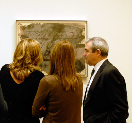 José Jiménez, comisario de la muestra, delante de la obra de Antoni Tàpies Grafismo sobre materia gris (1972)