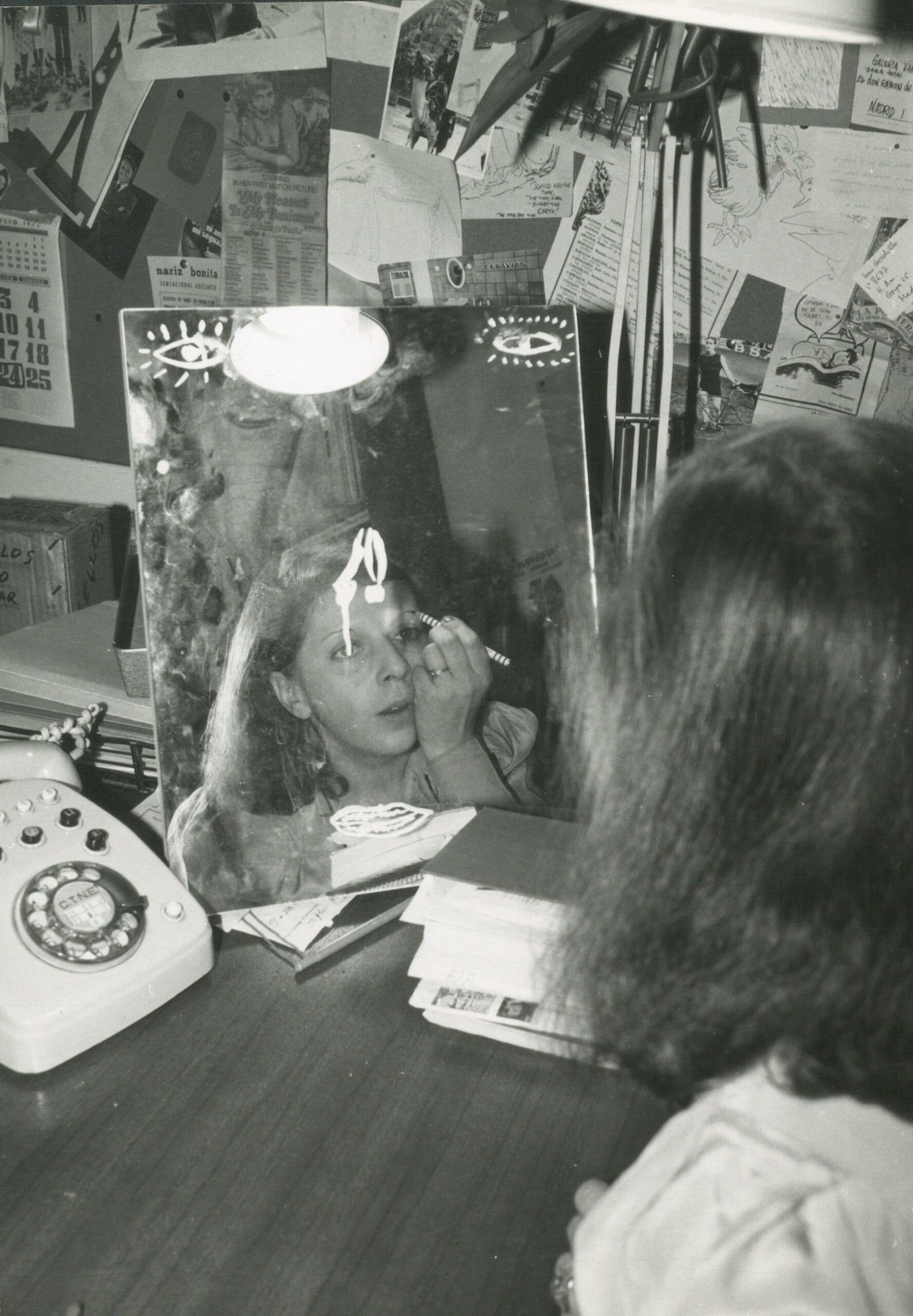 Blanca Sánchez reflejada en un espejo pintándose los ojos, Madrid, ca. 1975. Archivo Blanca Sánchez, Biblioteca y Centro de Documentación del Museo Reina Sofía ©Herederos de Blanca Sánchez 