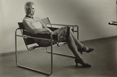 © Erich Consemüller, Lis Beyer or Ise Gropius sitting on the B3 club chair by Marcel Breuer and wearing a mask by Oskar Schlemmer and dress fabric by Beyer, c.1927. Herzogenrath, Berlin. © Estate Erich Consemüller