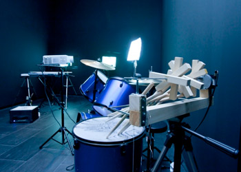 Julio Adán. Ecografía (no tocar, por favor), 2011. Guitarra eléctrica, bajo eléctrico, batería, piano eléctrico,  amplificadores, cámaras, proyectores, motores, sensores, papel, polvo de grafito y cables. Cortesía del artista 